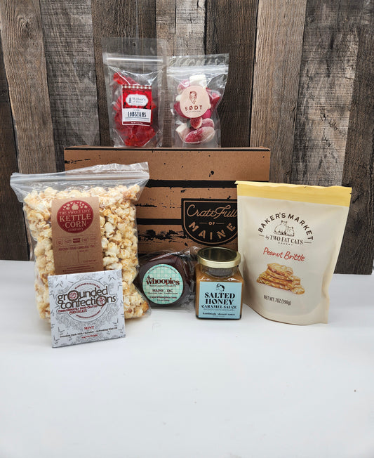 Assorted Maine snacks and treats on a white surface with a wooden background